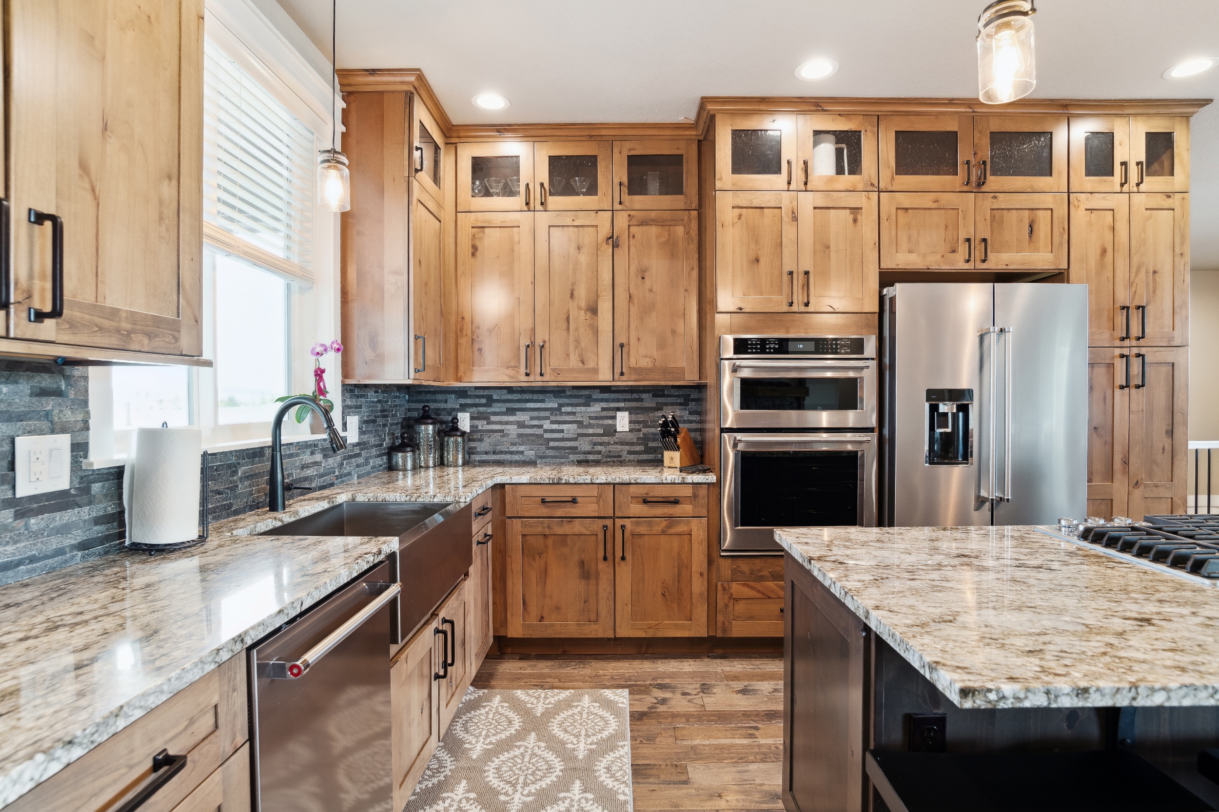 Knotty Alder Cabinets with pull out shelves, Farmhouse Sink, Kitchen Aid Appliances and Granite Counters
