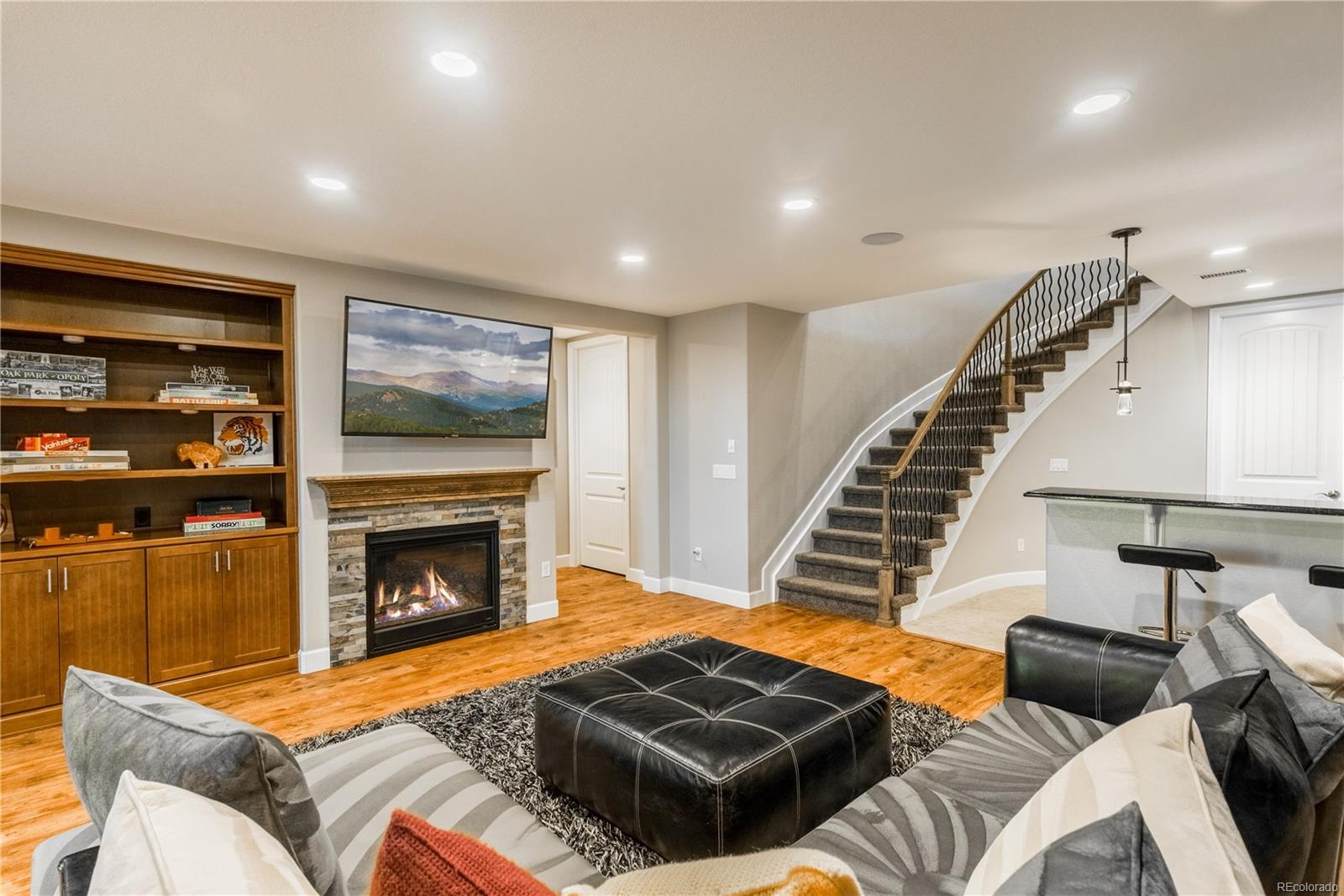 Lower level with extended wood flooring, fireplace and open bar area.