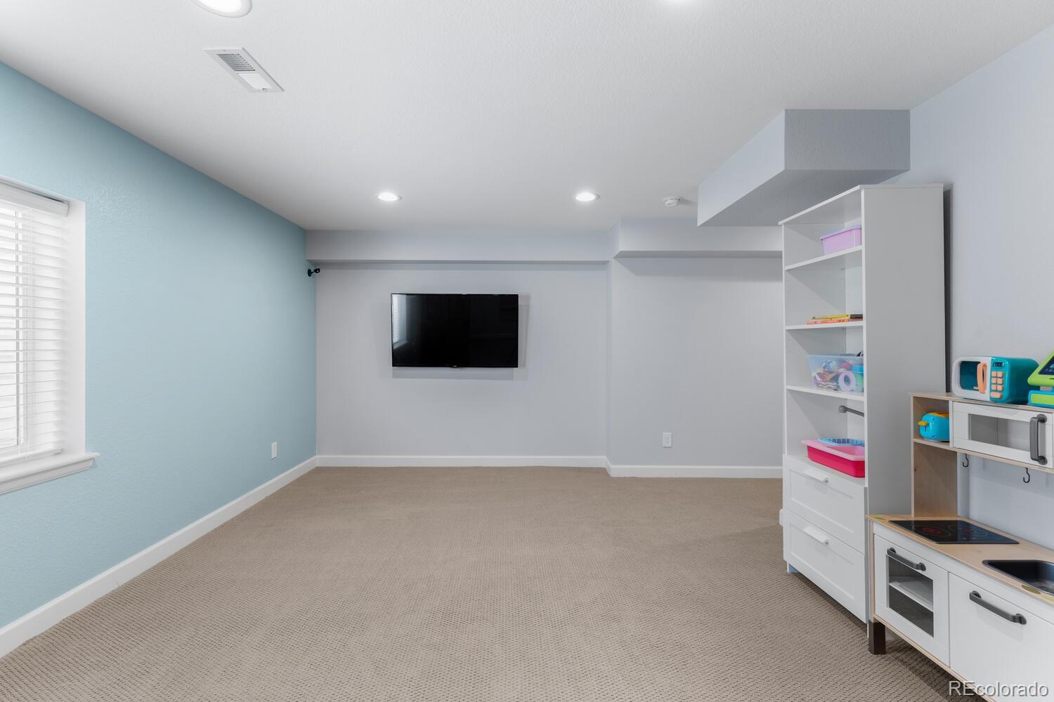Basement game or media room with an egress window