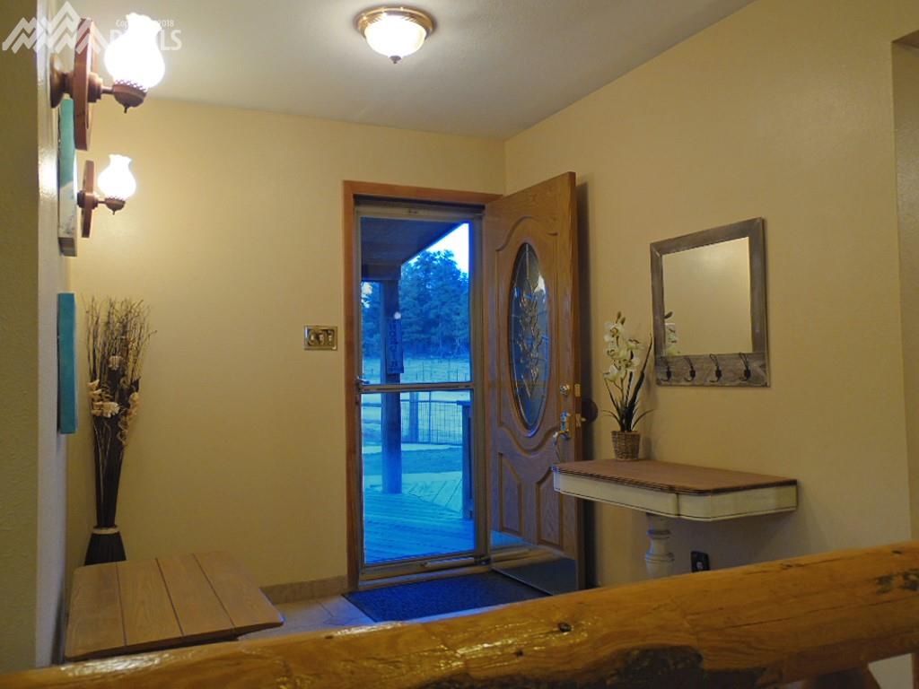 Foyer With Etched Glass Door and Log Railing