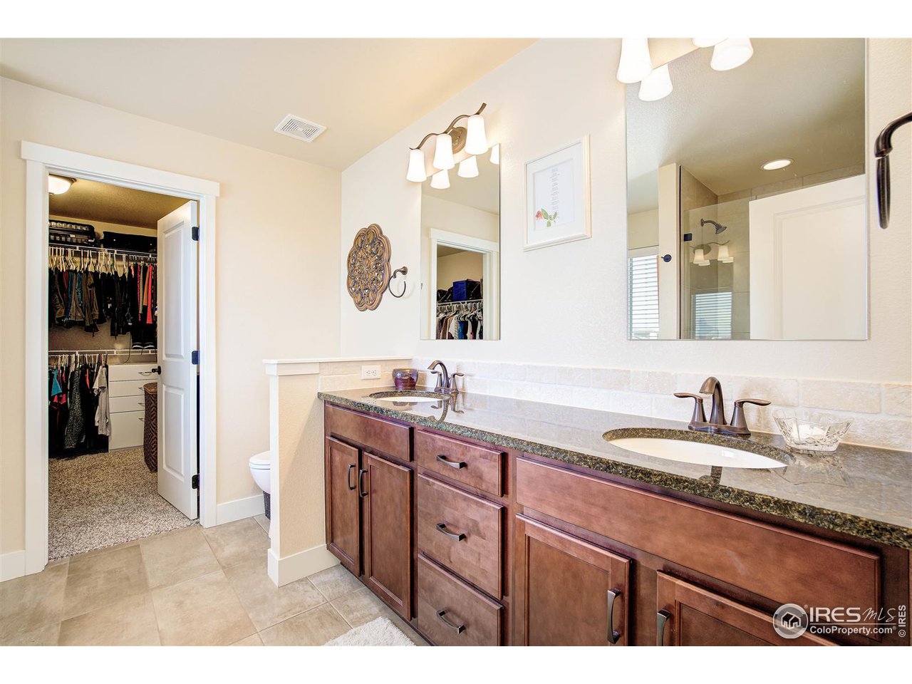 Comfort height stone counters, dual vanities, tile floors, and large walk-in closet