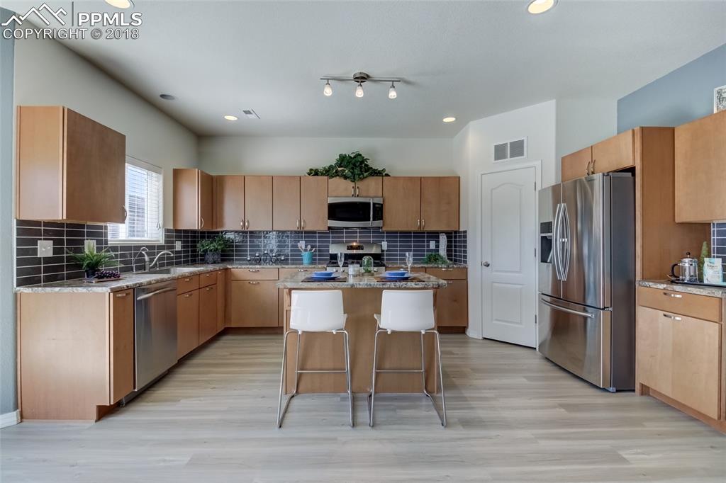 Beautiful kitchen with stainless steel appliances and center island with bar are