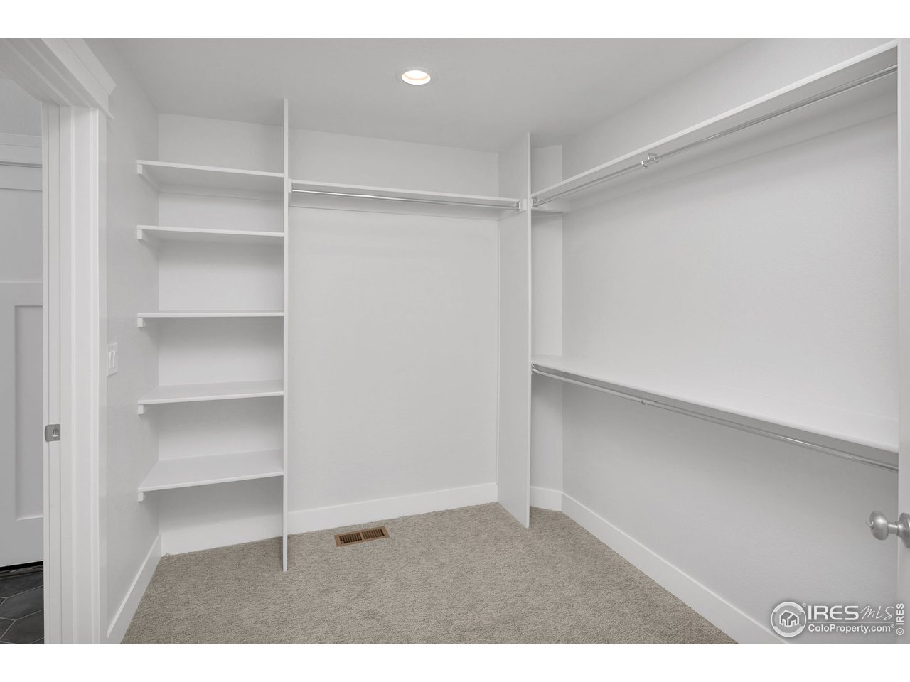 The walk-in primary closet, with a convenient door to the laundry room