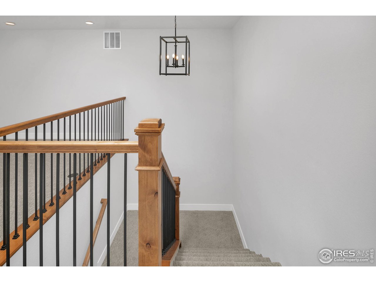 Stylish wood banisters & wrought iron balusters define the space 