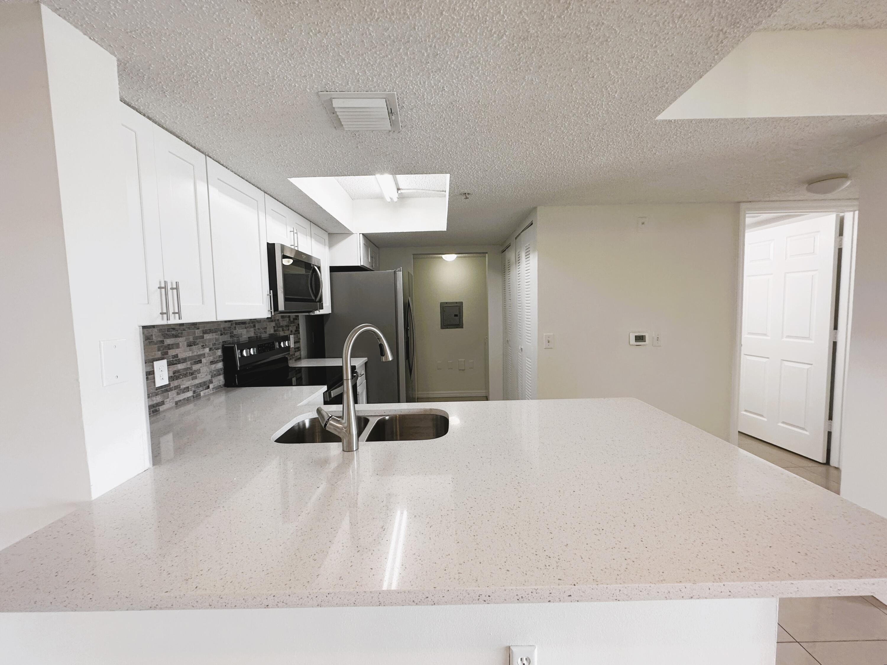 with white wood cabinets and quartz tops