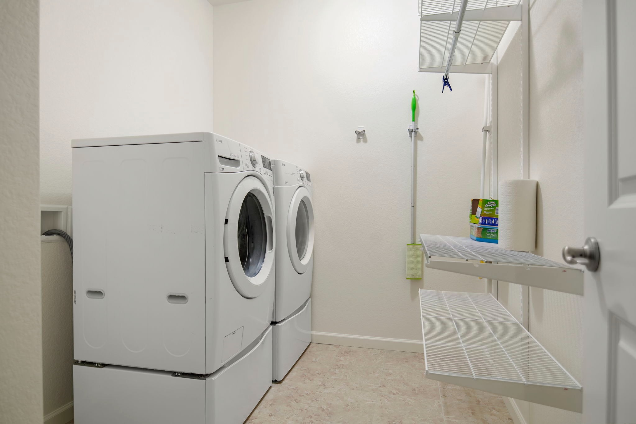 Convenient main-floor laundry includes LG front-loading machines and plenty of shelving for storage. 