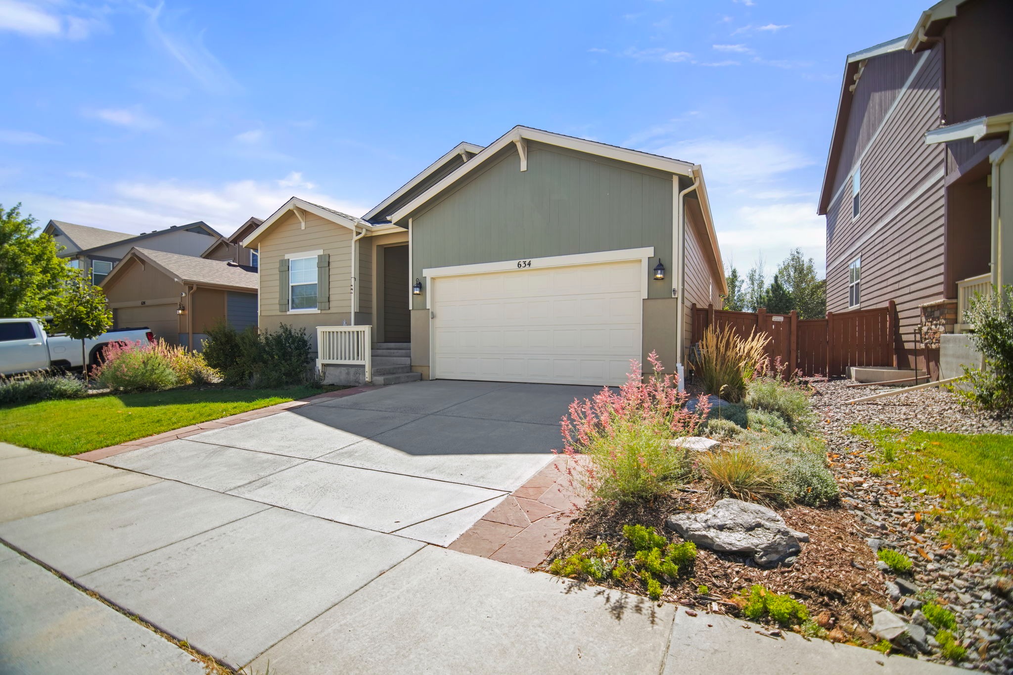 Exterior features custom flagstone pathways, an upgraded front door, and lighting.