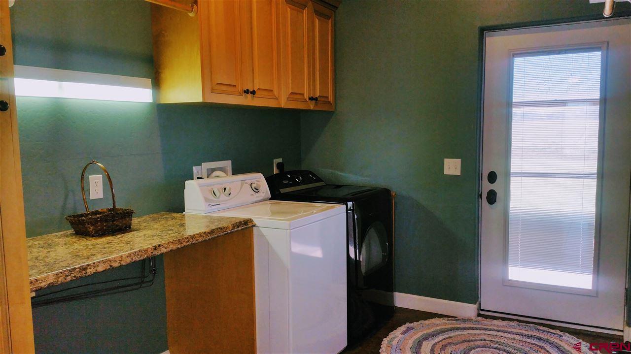 The spacious Laundry Room has a door going to back yard and patio.