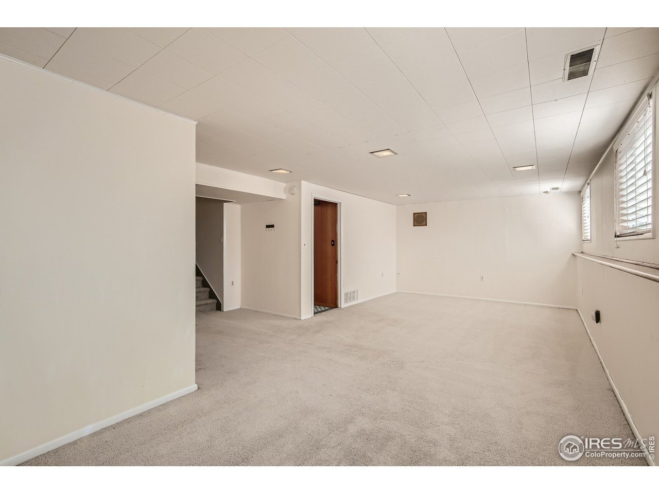 Spacious basement looking opposite to stairs up and utility, washer and dryer, storage room.