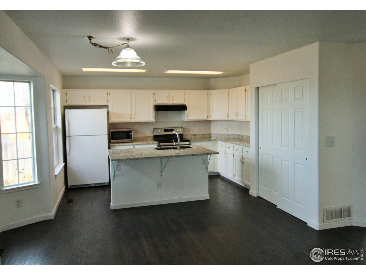 Kitchen has lots of cabinet and counter space + a big double door pantry & hardwood flooring.