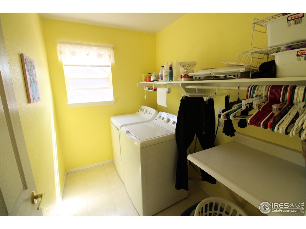 Upper level laundry room with folding table and space to hang clothes.